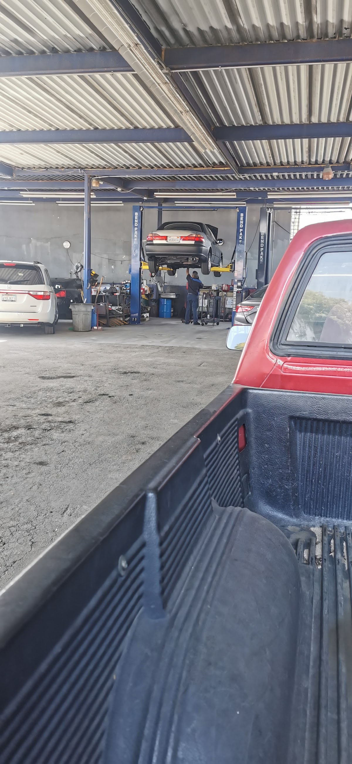 A mechanic working under a car on the lift at Twins Auto Repair